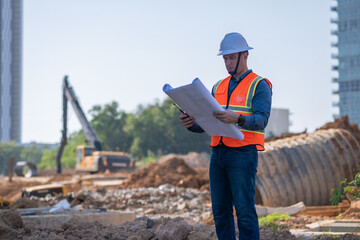 Engineer worker operations construction plans large black drainage pipe installing underground...