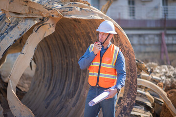 Construction surveyor or engineer working inspection damaged black corrugated pipe and construction...