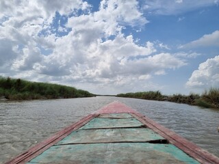 Boat Journey on a River Under a Cloudy Sky