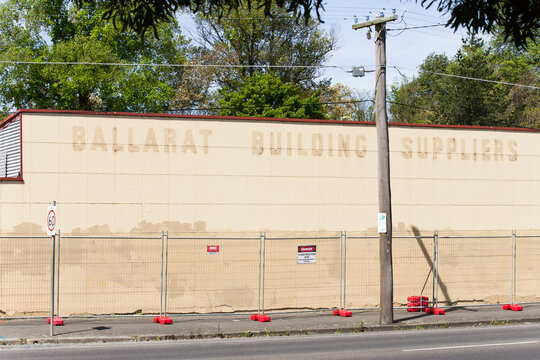 Fenced off wall of old building with faded signage
