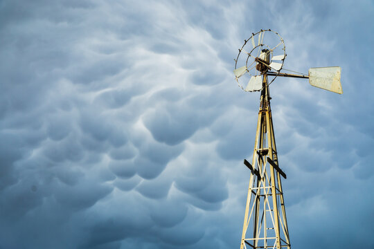 A broken windmill with dark mammatus clouds above