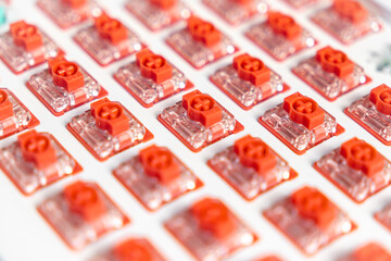 Macro view of installed red mechanical switches arranged on white custom keyboard plate