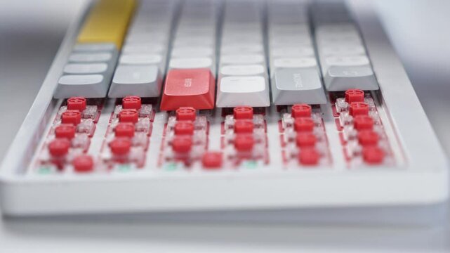 Hand pressing colorful keycaps onto red mechanical switches while assembling a custom keyboard