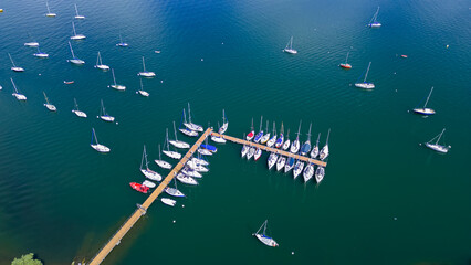 Aerial view of numerous sailboats anchored peacefully in a tranquil harbor. A picturesque maritime...