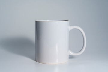 Empty white ceramic mug on light gray background