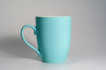 White ceramic mug with black coffee casting shadow on light surface