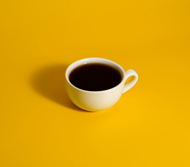 Coffee cup on yellow background with shadow