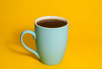 Turquoise coffee mug on yellow background
