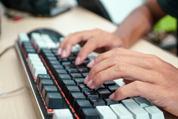 Close up of a male hands typing on a modern keyboard