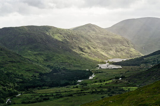 Stunning view of Blackvalley in Ireland showcasing lush green mountains and a serene river at dusk.