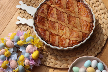 Italian traditional Easter cake called Pastiera on wooden table with ceramic bunnies and Easter eggs