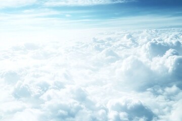 High-altitude view of fluffy cumulus clouds.  Vast expanse of white clouds stretching as far as the eye can see, bathed in sunlight from above.  A breathtaking panorama of the sky seen 