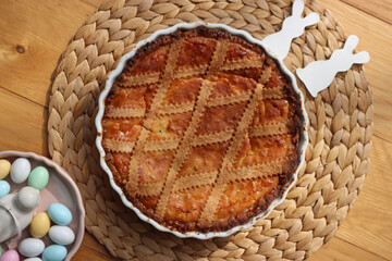 Italian traditional Easter cake called Pastiera on wooden table with ceramic bunnies and Easter eggs