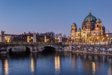 Obraz premium The Berlin Cathedral and a bridge over a canal at night