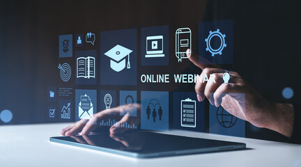 Hand interacting with online webinar interface on tablet in dark environment.