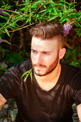 Young man relaxing outdoors with greenery around him