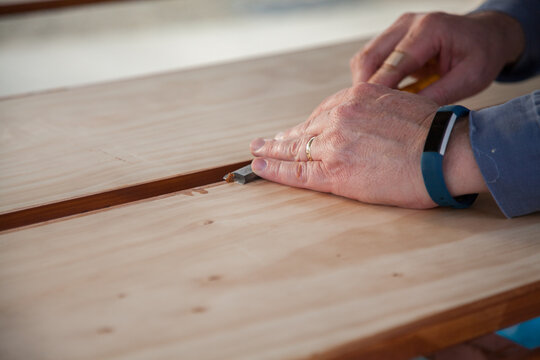 Man using chisel to smooth edges of timber