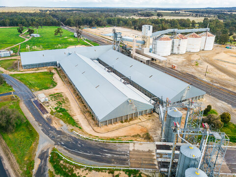 Looking down on roads and railways lines running to a collection of grain silos