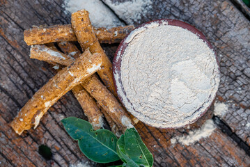 Withania somnifera ( Ashwagandha) dried root, Root powder, green leaves herbal plants on old wooden background. Herbal adaptogen ayurvedic medicine