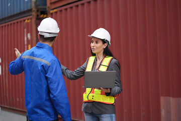 Caucasian man and woman engineer worker working and talking together at container site	