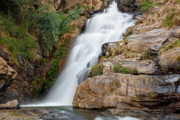 A waterfall is flowing down a rocky cliff