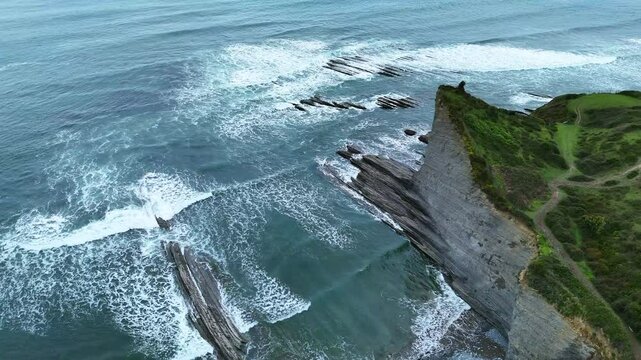 Verdure sur pointe de roche FLysch au bord de l'oc&eacute;an vu du ciel, Mont&eacute;e lente 
