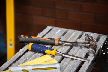 Builders tools and hammer lying on construction site