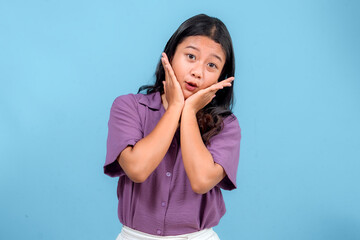 Young Asian woman making a surprised and cute facial expression while framing her face with her...