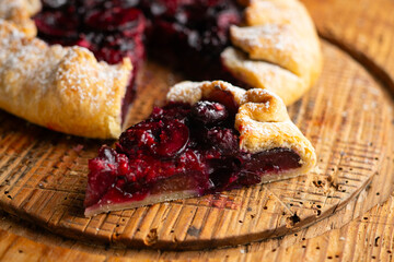 Galette tart with red berries, cherries, raspberries and blackberries. Top view table with christmas decoration.