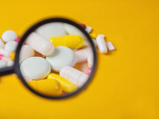 Pills of different shapes and colors on a spectacular background: an illustration of...