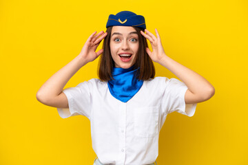 Airplane stewardess Ukrainian woman isolated on yellow background with surprise expression