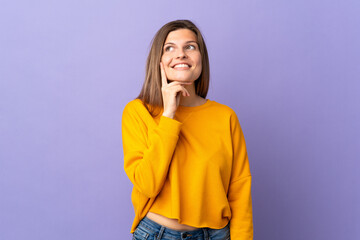 Young Slovak woman isolated on purple background thinking an idea while looking up