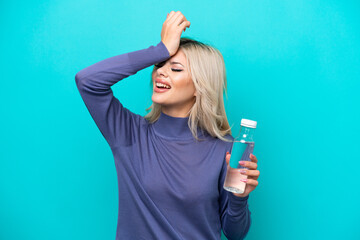 Young Russian woman with a bottle of water isolated on blue background has realized something and...