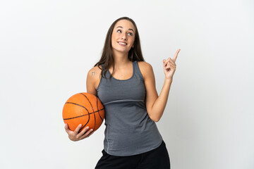 Young woman playing basketball over isolated white background pointing up a great idea