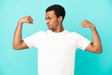 African American handsome man on isolated blue background doing strong gesture