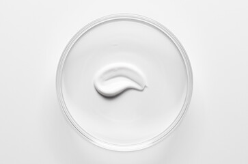 A sample of cosmetic moisturizing or anti-aging cream in a petri dish.
