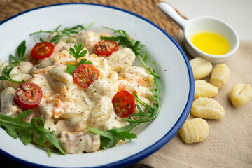 Italian gnocchi salad with cream and arugula. Top view table.