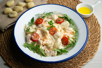 Italian gnocchi salad with cream and arugula. Top view table.