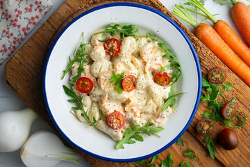Italian gnocchi salad with cream and arugula. Top view table.