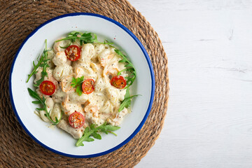 Italian gnocchi salad with cream and arugula. Top view table.