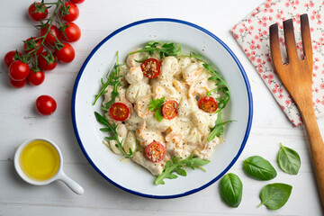 Italian gnocchi salad with cream and arugula. Top view table.