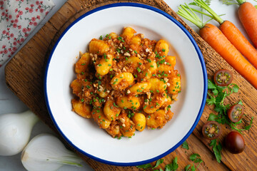 Dish of Italian gnocchi with tomato and meat Bolognese sauce. Top view table.