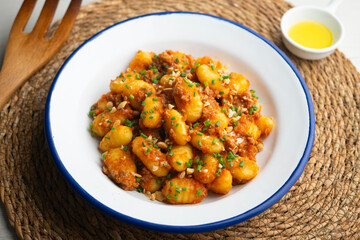 Dish of Italian gnocchi with tomato and meat Bolognese sauce. Top view table.