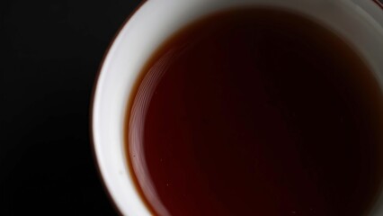 A Warm and Inviting Cup of Steaming Brewed Tea Comfortably Resting on a Dark, Rich Surface. Media