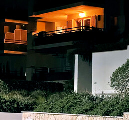 Night shot. Balcony of the house is painted light orange by the light bulb. Mallorca Island. Spain