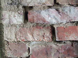 Patterns and textures of weathered bricks in a rustic wall reflecting years of history and craftsmanship
