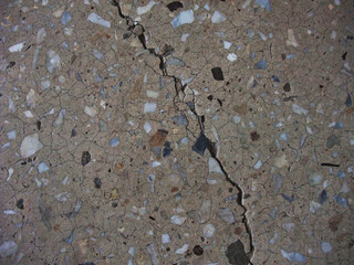 Cracked textured surface highlighting a unique blend of stones and minerals in natural light