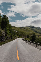View from a car window onto a highway in Norway in a mountain valley where metal barriers have been installed for safety purposes