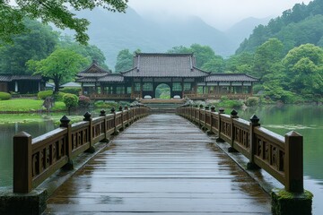 Fototapeta premium Bridge over water leads to a building surrounded by trees and mountains.