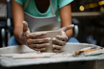 African woman make earth ware at workshop.